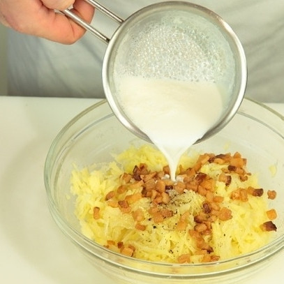 1. Этап. Кугелис: Смешайте тертый картофель и жареное сало. Добавьте теплое молоко.