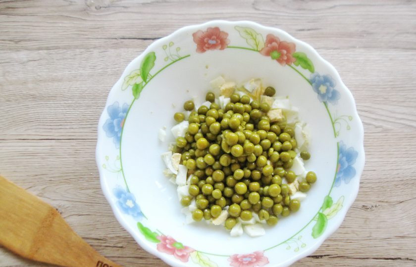 1. Этап. Жареный Оливье: Яйца сварите вкрутую, охладите, очистите и мелко нарежьте. Добавьте консервированный зеленый горошек.