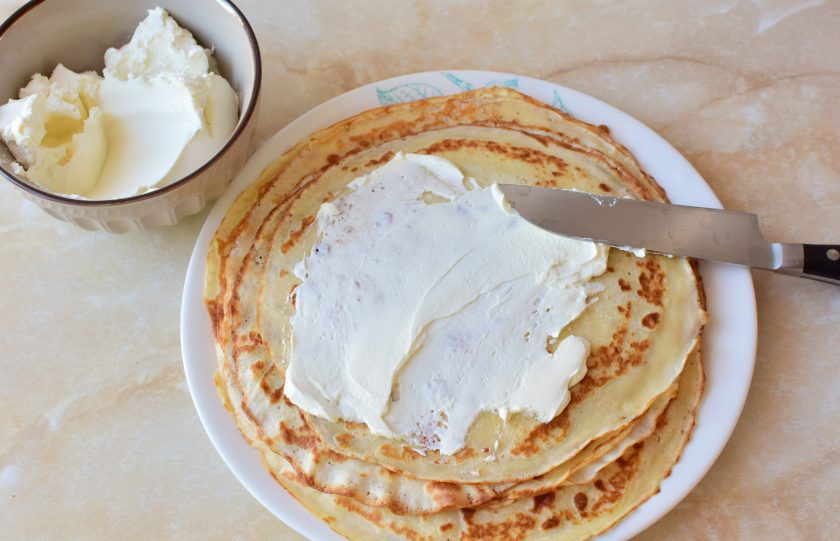 1. Этап. Блины с маскарпоне: Остывшие блины смажьте сыром маскарпоне и сверните.