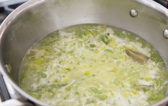 1. Этап. Суп-пюре с сельдереем: Через 7 минут влейте бульон, положите лаврушку, вскипятите. Готовьте 15 минут.