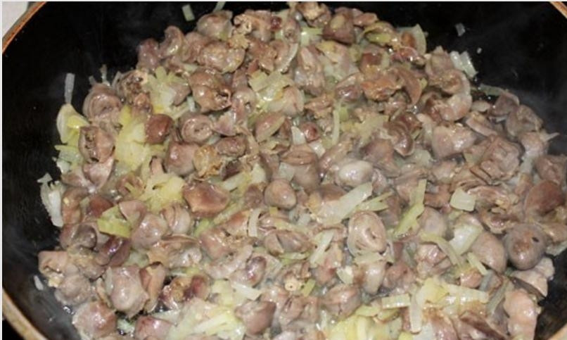 1. Этап. Тушеные потроха: 5. К обжаренным желудочкам и сердечкам добавьте лук, который предварительно очистите от шелухи и нашинкуйте полукольцами (или как вам удобно). Тушите, помешивая, около 8-10 минут.