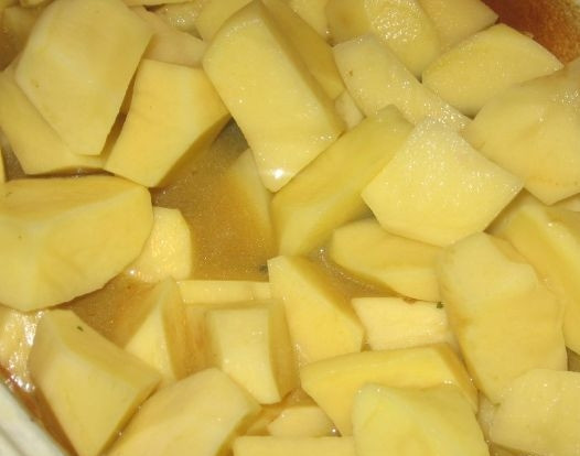 1. Этап. Гусь с картошкой: Чистим картошку, моем и нарезаем на кусочки. Выкладываем картошку поверх мяса гуся и доливаем немного воды или бульона - уровень жидкости должен быть чуть ниже картошки. Добавляем травы, досаливаем, если нужно. Закрываем блюдо и ставим в духовку еще на 1-1.5 до готовности картошки.