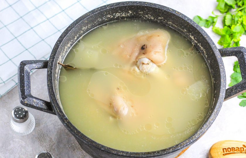 1. Этап. Желе из мясного бульона: Всыпьте соль, приправу. Можно добавить и другие специи и пряности. Очистите зубчики чеснока и спрессуйте их в бульон.