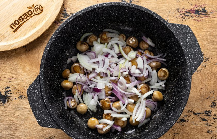 1. Этап. Грибы по-гречески: Затем добавьте нарезанный репчатый лук полукольцами. Обжарьте его до мягкости.