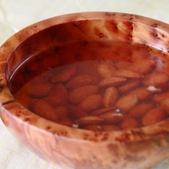 1. Этап. Греческий новогодний торт: Сперва замочим миндаль в кипяченой воде на пару минут, снимем с миндаля кожуру, подсушим его на сухой сковороде и измельчим в крошку при помощи мельницы или блендера.