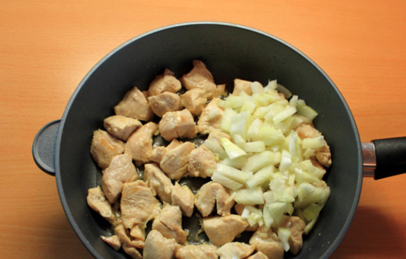 1. Этап. Куриное филе кусочками: Как только мясо начнет белеть, добавьте измельченный репчатый лук.