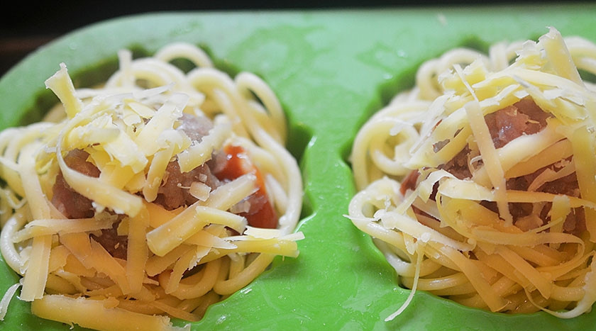 1. Этап. Кексики из спагетти с фрикадельками: 5. Посыпьте тертым сыром. Запекайте в разогретой до 180 градусов духовке около 40 минут.