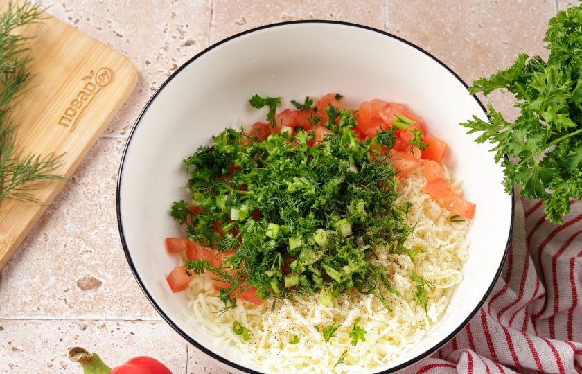 1. Этап. Жареный болгарский перец с сыром: В это время приготовьте начинку. Сыр натрите на мелкой тёрке. Половинку помидора нарежьте мелкими кубиками, сочную часть лучше убрать. Зелень порубите ножом. Добавьте соль и перец по вкусу.