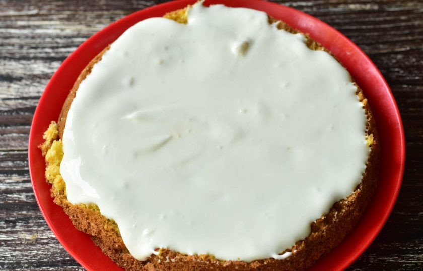 1. Этап. Морковный торт с ананасами: Разрежьте бисквит на три части. Промажьте один корж сметанным кремом.