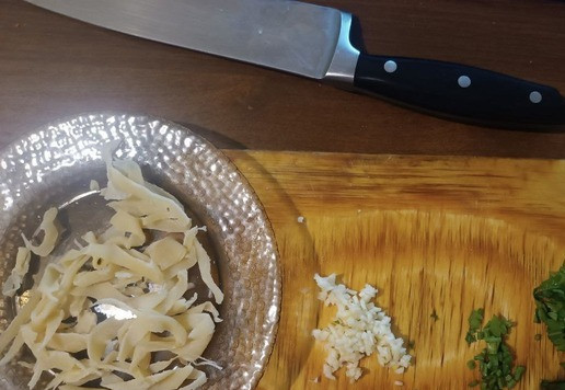 1. Этап. Яичная лапша с кальмаром и овощами: Так как у меня покупные кольца кальмара, то я их рву на узкие полоски. Так же на полоски режу петрушку. Чеснок мелко режу - так вкуснее будет.