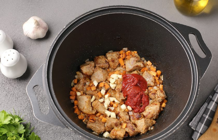 1. Этап. Картошка тушёная со свининой и фасолью: Затем добавьте томатную пасту и измельчённый ножом чеснок, можно добавить 1 ч.л. сахара. Перемешайте и готовьте ещё пару минут.