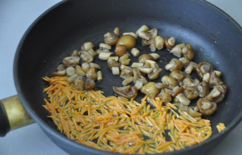 1. Этап. Куриная лапша с опятами: Влейте растительное масло на разогретую сковороду, обжарьте сначала морковь, затем добавьте к ней опята и обжарьте до готовности. Если есть желание, то можно добавить при обжарке лук.