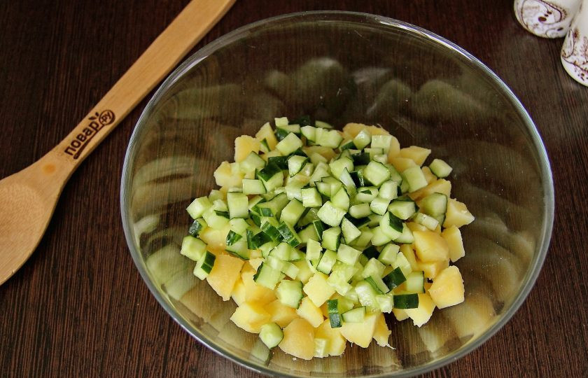 1. Этап. Салат из рыбных консервов с огурцом: Огурец нарежьте примерно такими же кубиками и добавьте к картофелю.