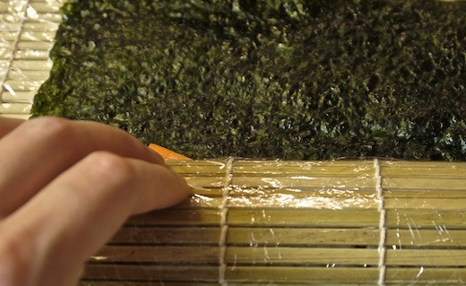 1. Этап. Роллы овощные: 8. С помощью коврика начинайте аккуратно сворачивать, чтобы получился плотный рулет.