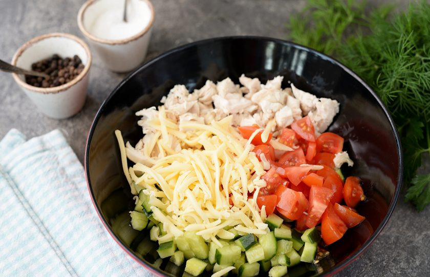 1. Этап. Салат Нежный с курицей: Любимый твердый сыр натрите на крупной терке, всыпьте в миску, добавьте нарезанные кубиком помидоры.