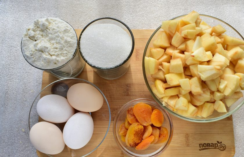 1. Этап. Шарлотка с курагой и яблоками: Яблоки очистите, нарежьте на мелкие кубики. Курагу измельчите.