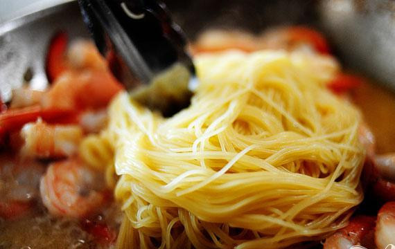 1. Этап. Тигровые креветки с макаронами: 5. Снять сковороду с огня. Добавить макароны и перемешать, добавляя макаронную воду в случае необходимости. Добавить приправы, соль и перец, если необходимо.