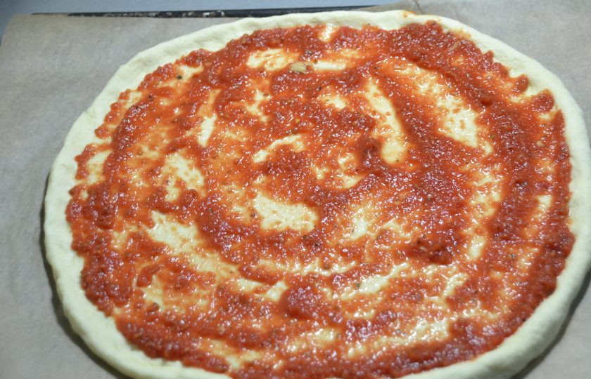 1. Этап. Пицца Примавера: Смажьте тесто томатным соусом или пассатой.