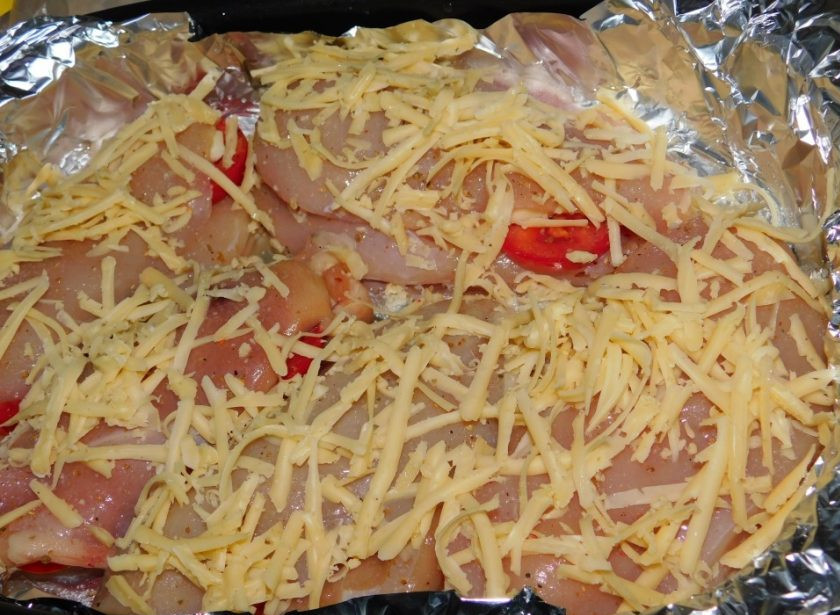 1. Этап. Запеченная куриная грудка с помидорами и чесноком: Закройте начинку второй половинкой грудки и выложите в форму для запекания. Сверху посыпьте тертым сыром. Поставьте в духовку, разогретую до 200 градусов на 40-50 минут.