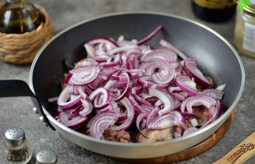 1. Этап. Куриная печень по-турецки: Добавьте в сковороду нарезанный полукольцами репчатый лук, обжарьте вместе с печенью на умеренном огне минуты 2, пока лук не станет мягким.