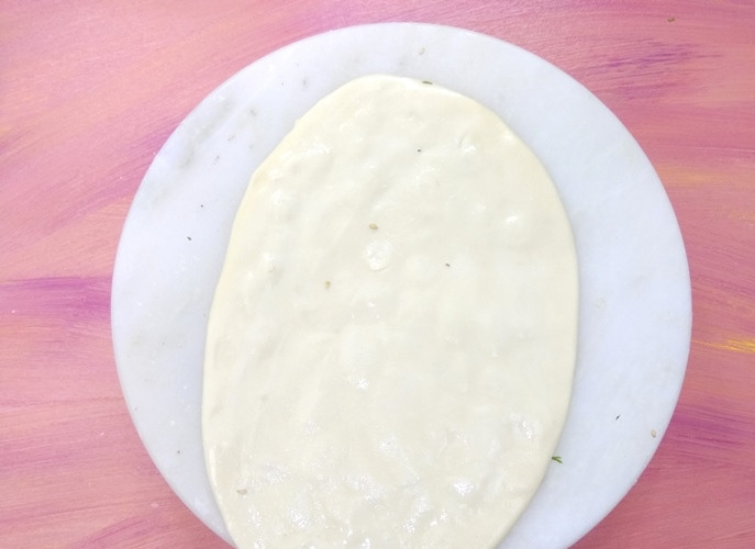 1. Этап. Индийские лепешки с чесноком: 3. Аккуратно перевернув тесто, смочите обратную сторону водой.