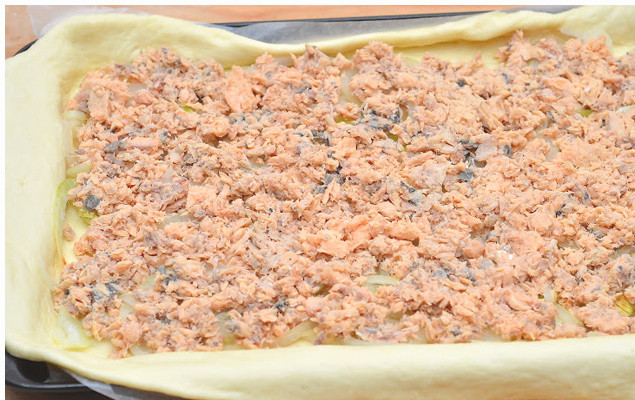 1. Этап. Рыбный пирог из песочного теста: 5. Раскатываем пласт теста и выкладываем его в форму для выпекания. Сверху выкладываем нашу начинку - консервы и лук.