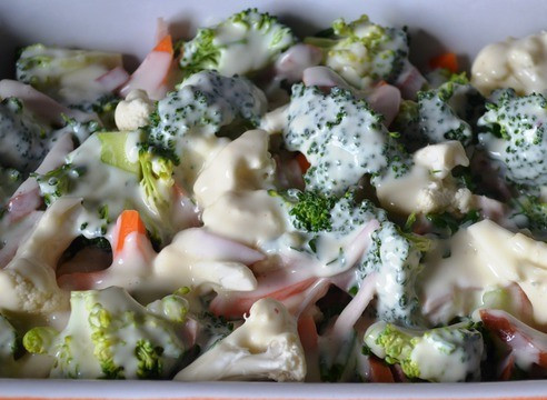 1. Этап. Запеканка с колбасой: Разогреваем духовку до 180 градусов и отправляем запекаться овощи, политые горячим соусом. Через 20 минут достаем форму, овощи перемешиваем, сверху посыпаем тертым сыром и готовим еще 20 минут.