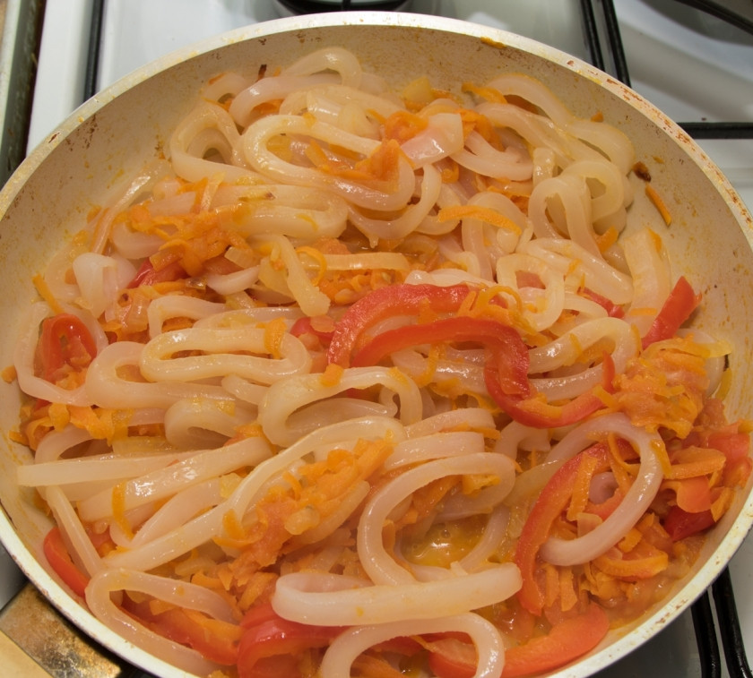 1. Этап. Жареные кальмары с овощами: Добавим к овощам кальмары и измельченный предварительно чеснок, посолим, поперчим по вкусу. Обжарим все вместе минут 7. Блюдо готово! Приятного аппетита!