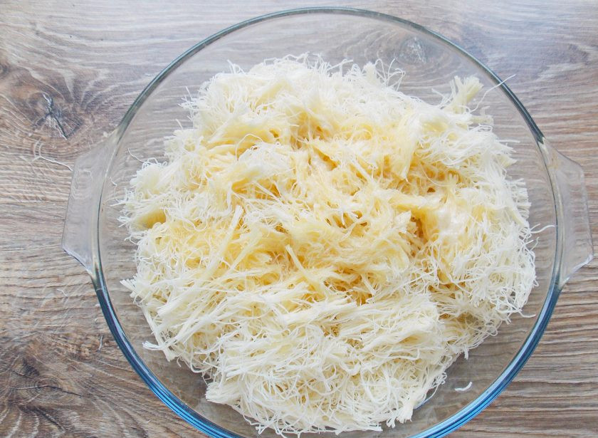 1. Этап. Кюнефе: Полейте тесто растопленным маслом с медом и хорошенько перемешайте, чтобы оно равномерно распределилось.