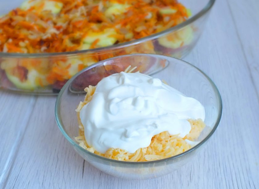 1. Этап. Горбуша с кабачком в духовке: В отдельную чашу натрите на средней терке сыр. Добавьте к нему сметану и перемешайте. При желании посолите.