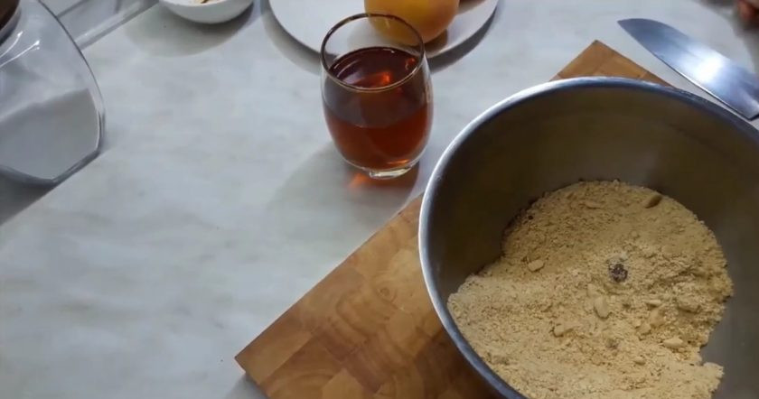 1. Этап. Вкусный десерт из персиков: 2. Добавьте в крошку печенья миндальную крошку, перемешайте и добавьте немного вина. Консистенция такой крошки должна быть как мокрый песок.