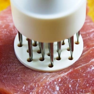 1. Этап. Свинина в панировке: Первым делом полкилограмма мяса разрезаем на 4 одинаковых по размеру куска. Каждый из них прокалываем при помощи тендерайзера. Делается это так, как на фото.