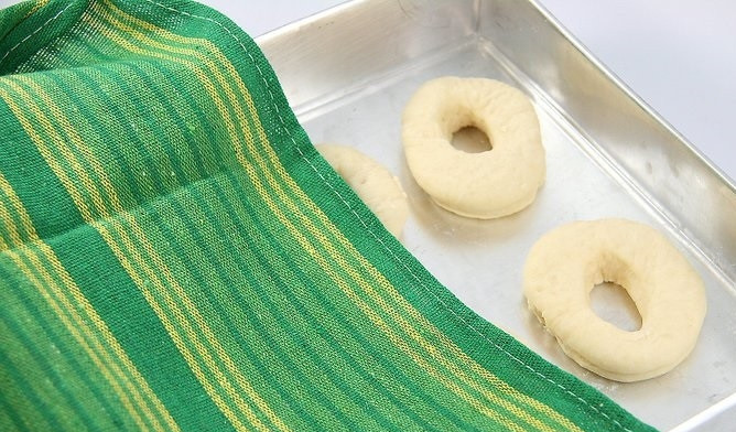 1. Этап. Рецепт воздушных пончиков: 6. Выложите пончики, прикройте полотенцем и оставьте еще минут на 20.