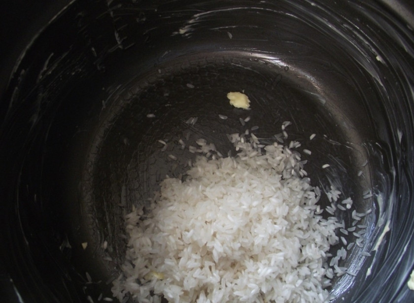 1. Этап. Молочная каша: Рис промойте, чашу мультиварки смажьте сливочным маслом. Выложите рис в чашу мультиварки.