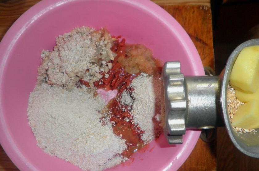 1. Этап. Печеночные котлеты в духовке: Пропускаем через мясорубку печень, лук, картофель и хлопья.