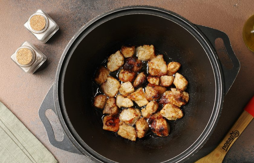 1. Этап. Плов из круглозёрного риса со свиной грудинкой и овощами: Разогрейте казан с маслом, выложите мясо и обжарьте на сильном огне до лёгкой золотистой корочки.