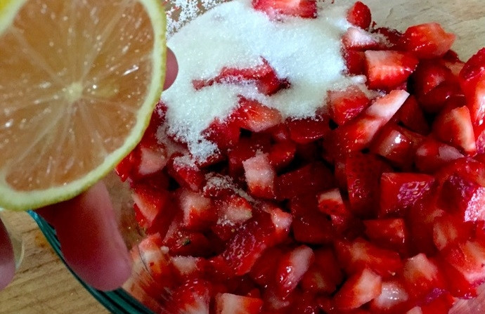 1. Этап. Печенье с клубникой: 1. Вымойте клубнику, нарежьте ее кубиками. Выложите в миску и добавьте к ней сахар, сок половинки лимона. Перемешайте и отставьте на время.