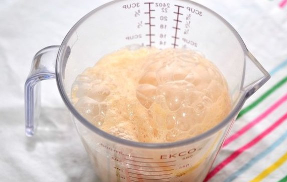 1. Этап. Сдобные пирожки с творогом: Для начала разогреваем воду градусов до 30-35, высыпаем в нее сахар и чайную ложку муки, добавляем дрожжи. Перемешиваем все, накрываем опару полотенцем и ставим в тепло на 15-20 минут.