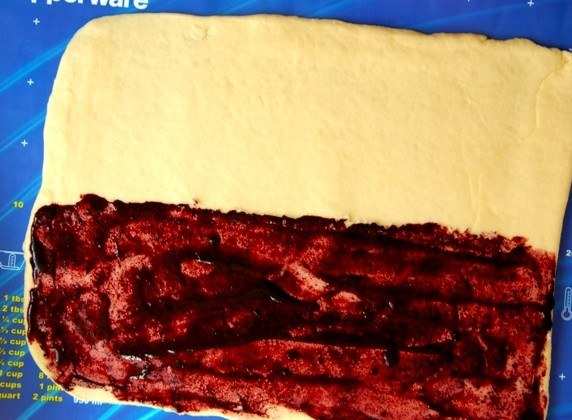 1. Этап. Пирожки с черникой: Половину прямоугольника намажьте половиной марципановой смеси, вдоль длины. Сверху намажьте черничным варением.