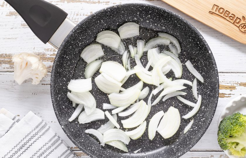 1. Этап. Картофель с брокколи и цветной капустой: Разогрейте сковороду на среднем огне с растительным маслом. Добавьте нарезанный перьями репчатый лук. Обжарьте 2-3 минуты до прозрачности. Затем добавьте измельченный чеснок.