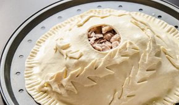 1. Этап. Курник из слоеного теста: Чтобы закрыть третий слой из курицы нам понадобится оставшееся тесто. Раскатываем из него максимально тонкий слой, чтобы он закрыл весь пирог. В середине делаем дырочку. Края можно придавить ложкой. Смазываем тонкий слой теста сверху смесью из желтка и молока (предварительно размешать). Теперь можно положить пирог в духовку при температуре 175 градусов на 30-35 минут.