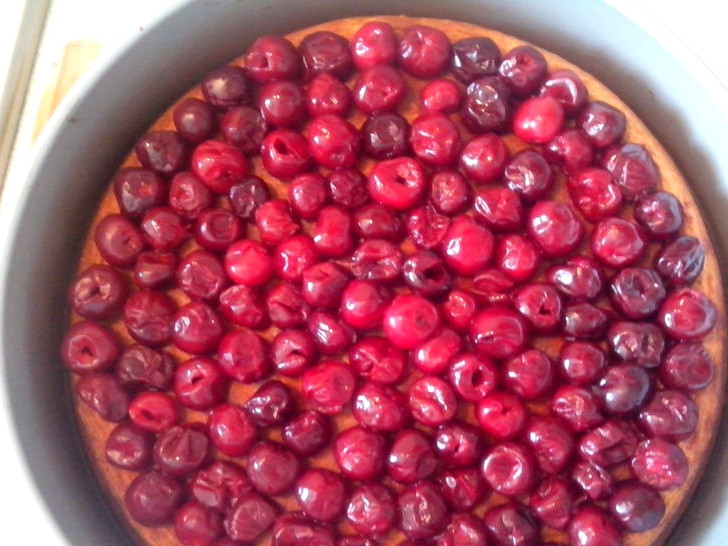 1. Этап. Торт с маскарпоне и вишней: Приступим теперь к вишне. Вы можете взять замороженные ягоды или консервированные, взятые из компота. Варенье, в принципе, тоже пойдет, только ягод нужно будет меньше. Вишню, естественно, берем очищенную, без косточек. Выкладываем ее на остывший бисквит.