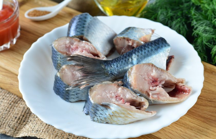 1. Этап. Селедка с кетчупом и луком: Сельдь разморозьте, почистите от головы, внутренностей и промойте со всех сторон и в брюшке. Нарежьте рыбу средними кусочками.