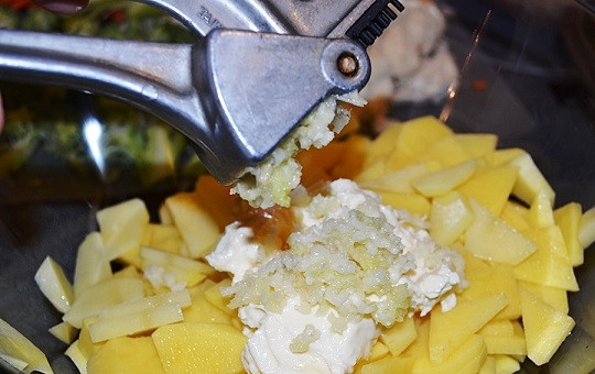 1. Этап. Красная рыба с овощами в духовке: 3. Выложите картофель в глубокую мисочку. Посолите немного по вкусу, добавьте майонез и пропущенный через пресс чеснок.