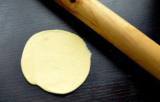 1. Этап. Вареники с сыром сулугуни: 5. Раскатайте небольшой кусочек теста и с помощью выемки или стакана вырежьте кружочки. Тесто должно быть раскатано довольно тонко.