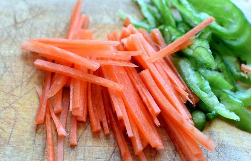 1. Этап. Грибная лапша на китайский манер: Нашинкуйте морковь тонкой соломкой, а перец — полукольцами. Опустите в суп и дайте закипеть. Затем добавьте стрелки чеснока, нарезанные небольшими кусочками, и снова дайте закипеть.