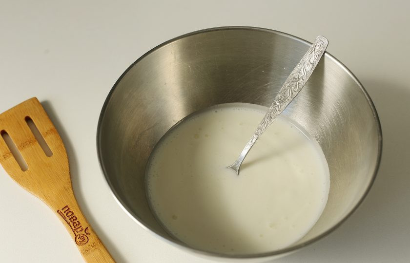 1. Этап. Оладьи на кефире с крахмалом: Перелейте кефир в глубокую миску, добавьте соду, перемешайте и дождитесь пузырьков.