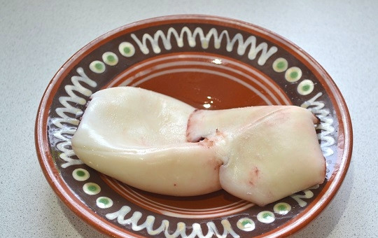 1. Этап. Салат Нежность с кальмарами: 2. Кальмар опустите в кипящую подсоленную воду и снимите кастрюлю с огня. Оставьте тушки минут на 5 в воде. После остудите и очистите.