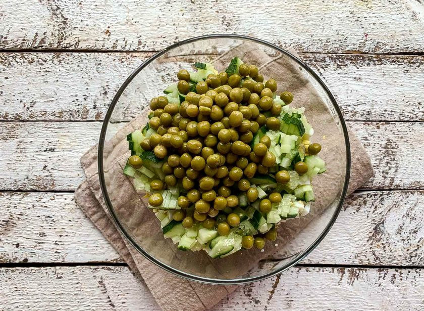 1. Этап. Салат с курицей и огурцами: Добавьте зеленый горошек.