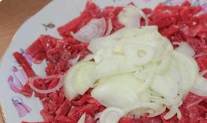 1. Этап. Мясное хе (оригинальный рецепт): Лук нарезаем полукольцами и выкладываем поверх говядины.